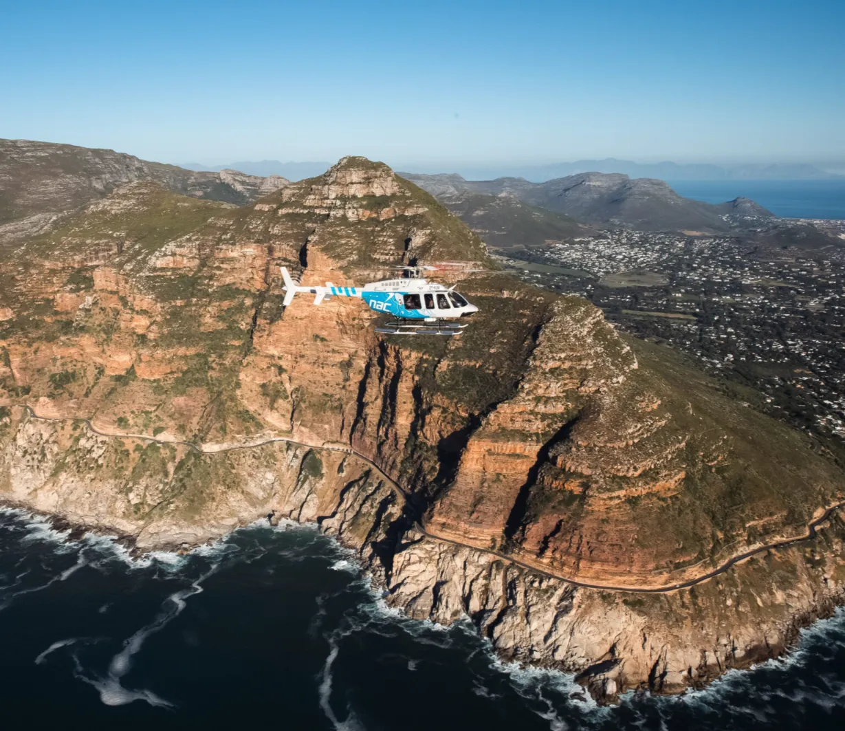 NAC helicopter flying along the cliffs of Chapman's Peak